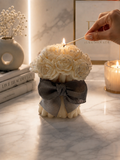 Rose Bouquet Sculptural Candle being lit with a match on marble surface