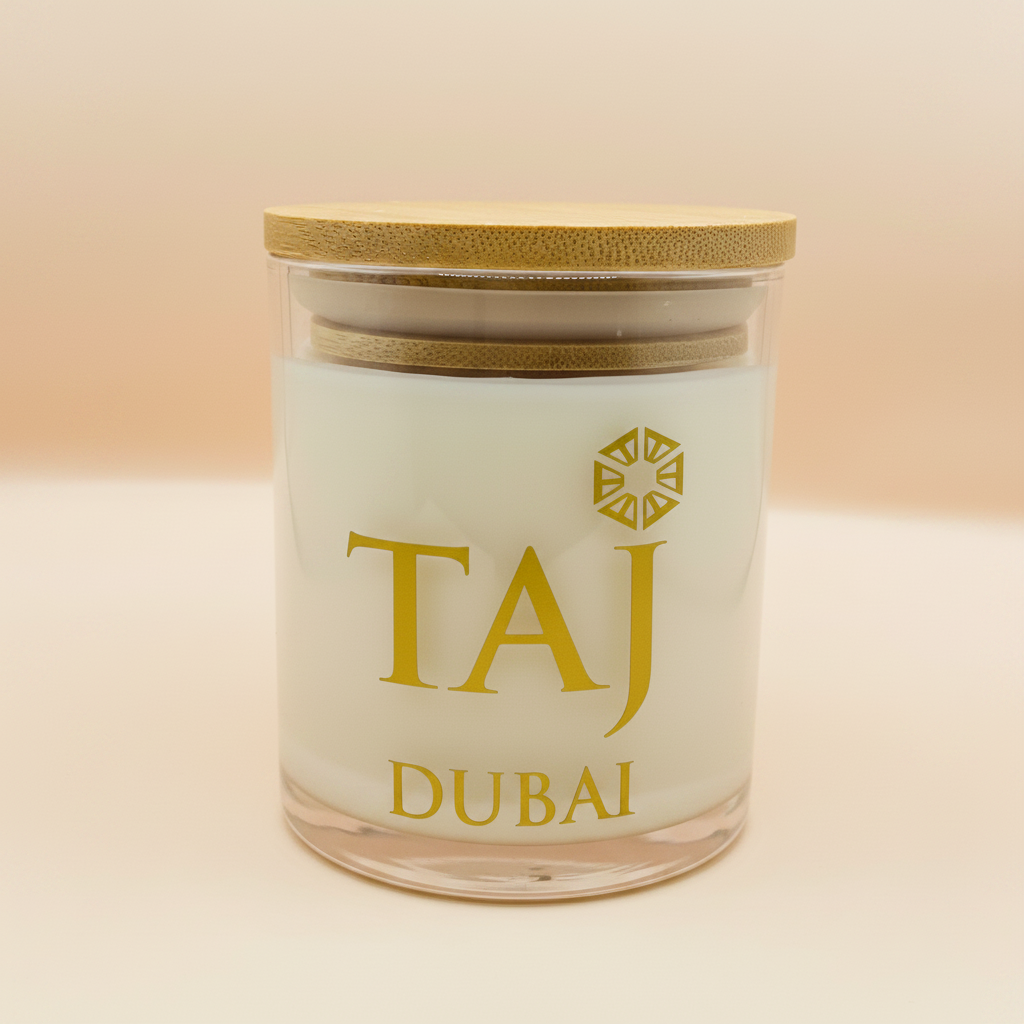 Glass jar candle with bamboo lid and gold label on warm ivory background