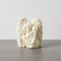 Guardian angel candle on grey concrete surface with white wall background